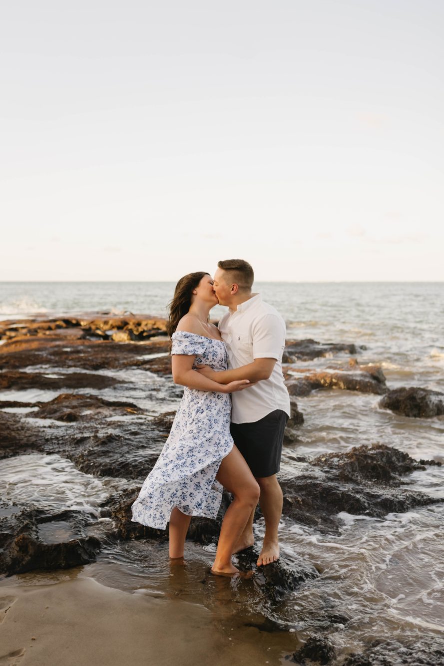 Couple kissing in the waves among the black rocks at Black Rock Beach near Amelia Island, Florida by Lee Photo + Video