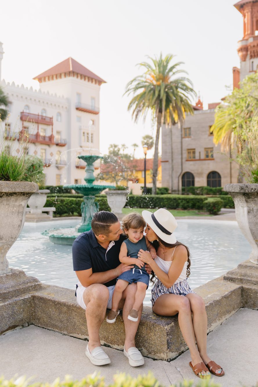 Family with toddler by the Lightner Museum courtyard fountain with palm trees in St. Augustine, Florida