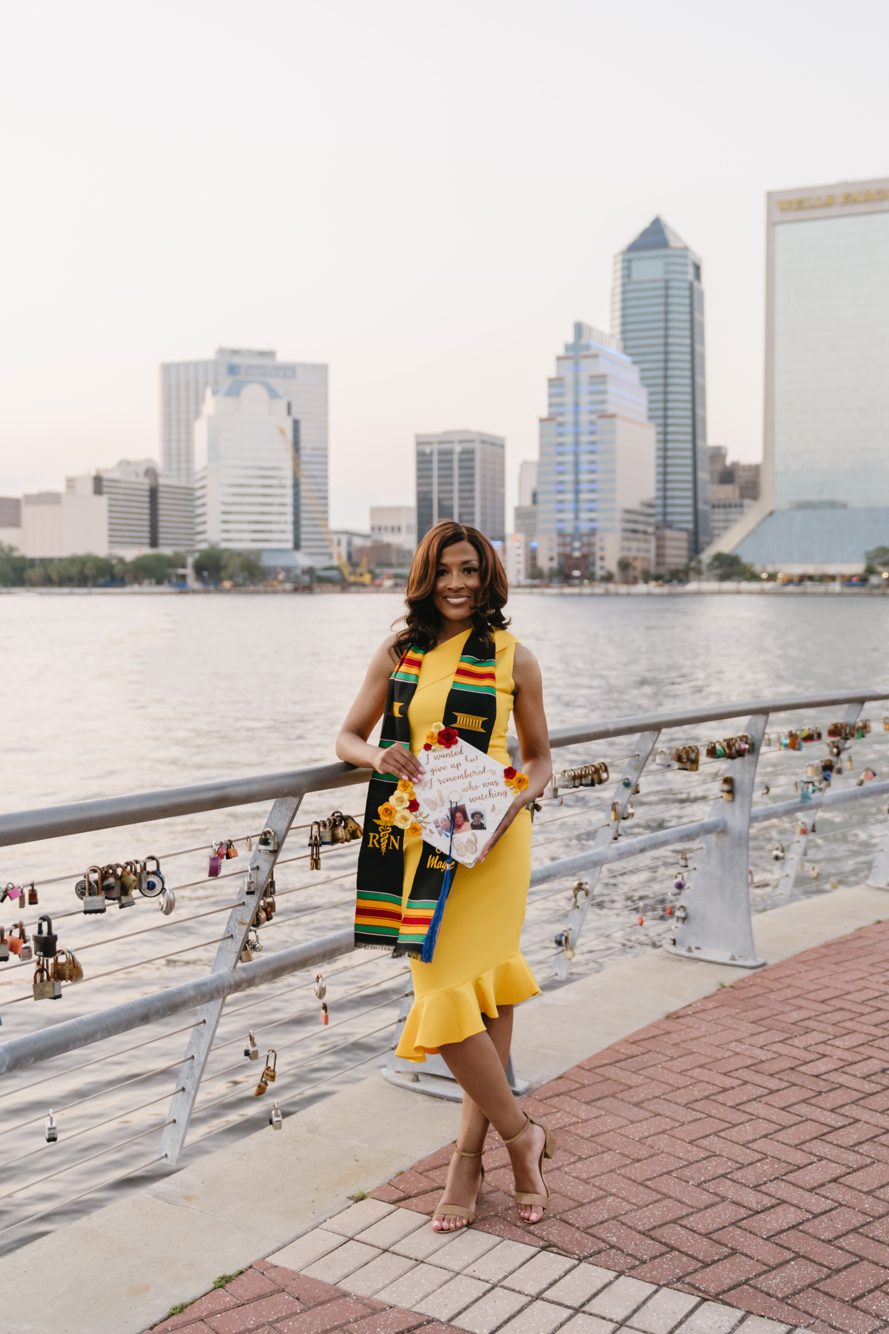 Graduation portrait session on the Southbank Riverwalk with the downtown Jacksonville skyline across the river