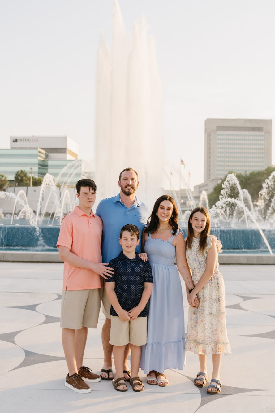 Family walking the Southbank Riverwalk with the Jacksonville skyline and Main Street Bridge behind them by Lee Photo + Video
