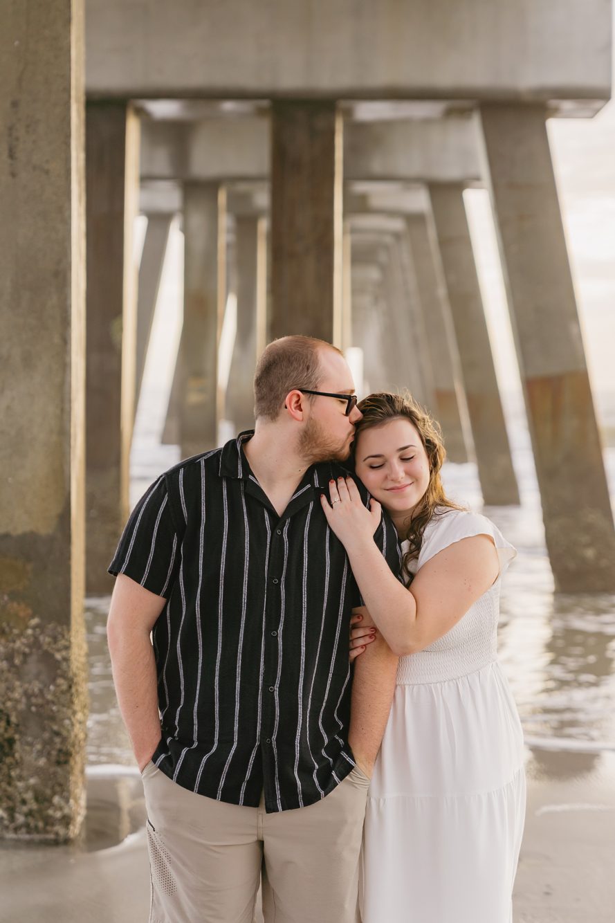 Senior portrait session leaning against the pilings under the Jacksonville Beach Pier by Lee Photo + Video