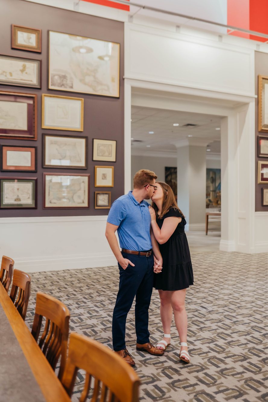 Couple kissing on the staircase beneath the colorful book mural inside the Jacksonville Main Library