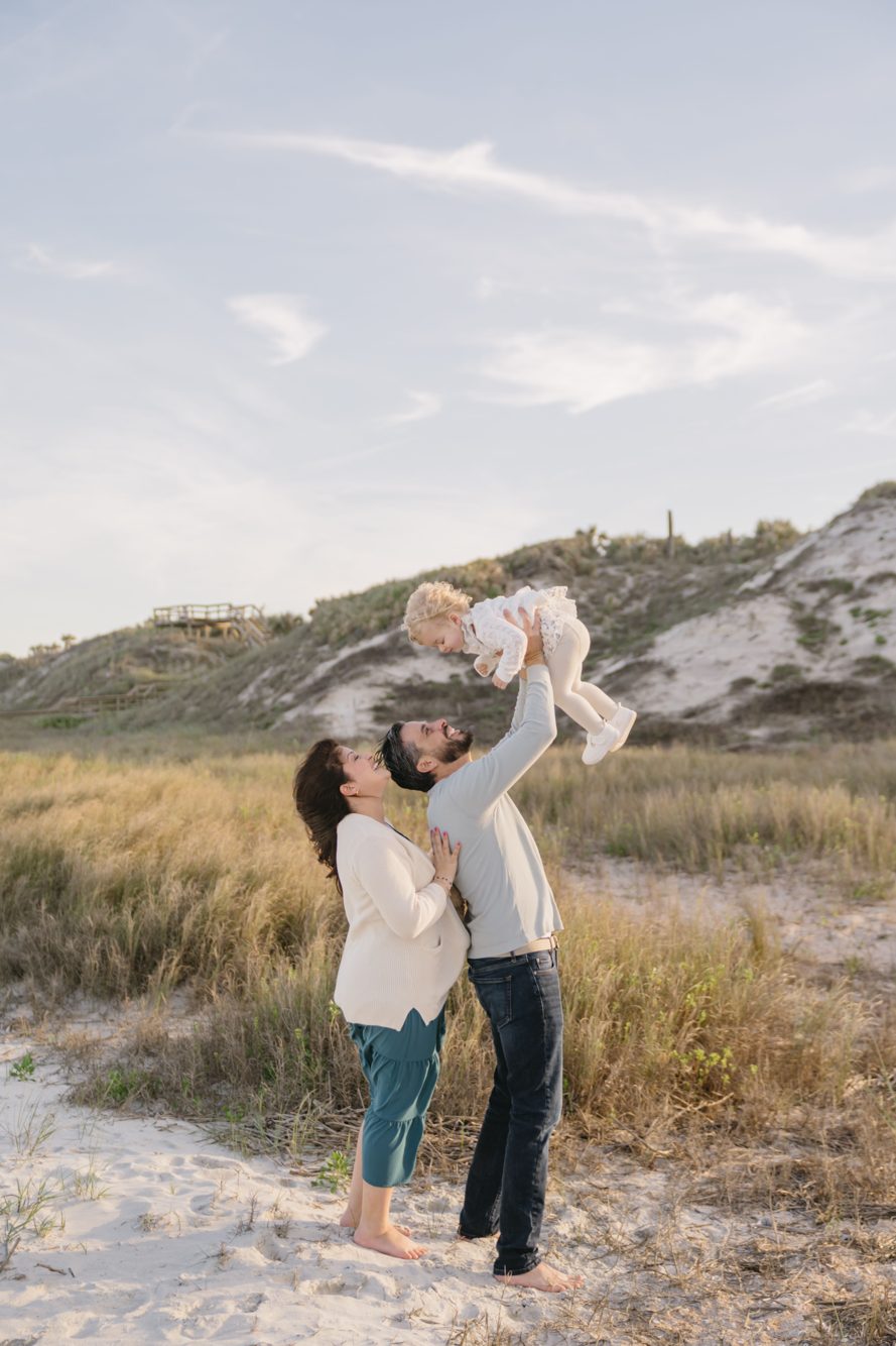 Parents lifting their toddler among the sea oats and rolling dunes at North Beach Guana by Lee Photo + Video