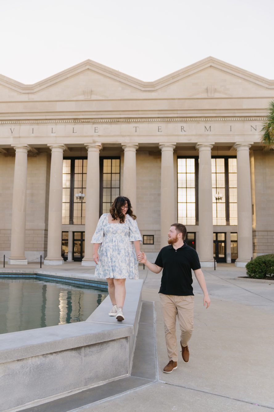 Couple holding hands by the reflecting pool in front of the historic Jacksonville Terminal columns at the Prime Osborn Convention Center