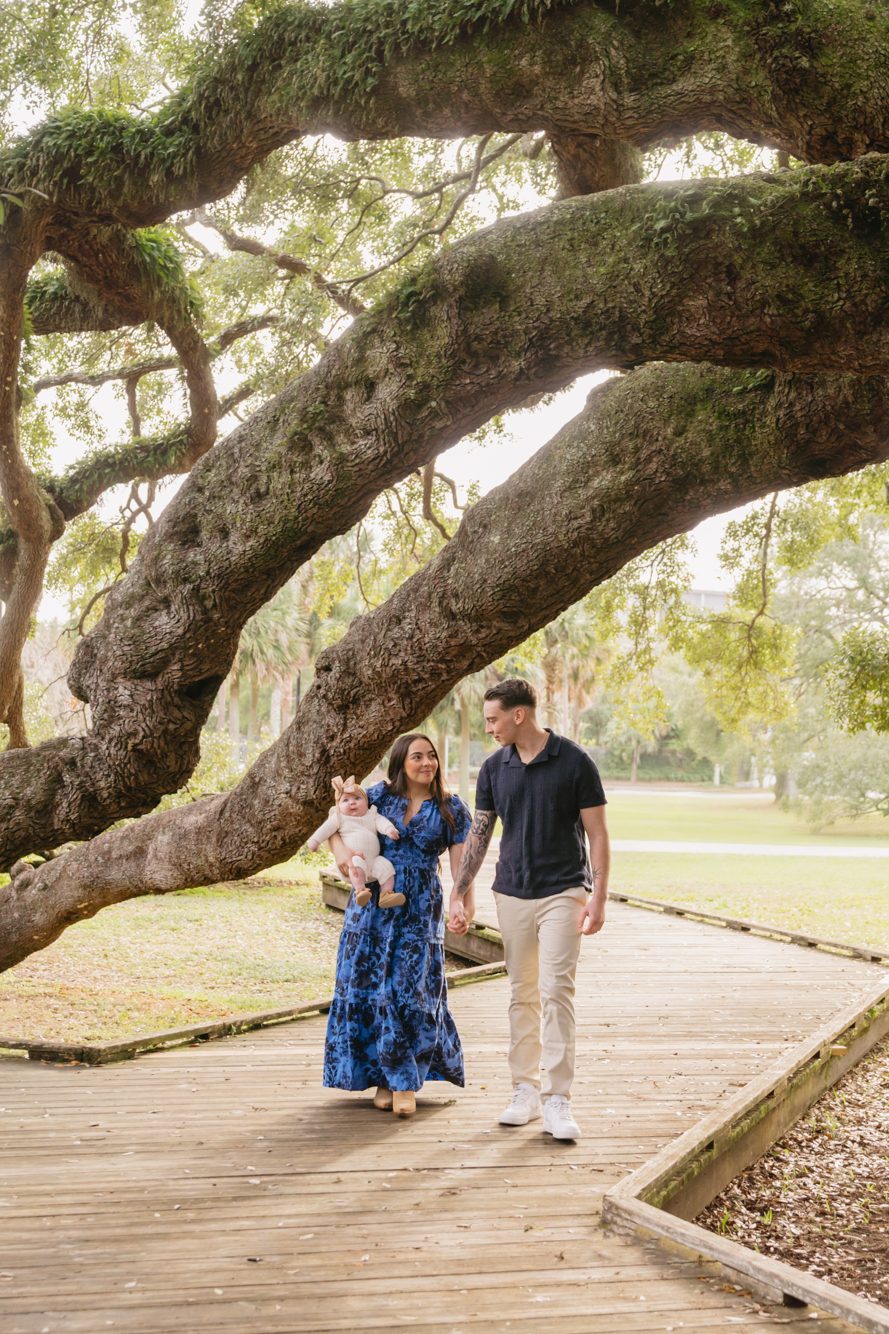 Couple kissing beneath the sprawling sunlit branches of the 250-year-old Treaty Oak in Jacksonville FL by Lee Photo + Video