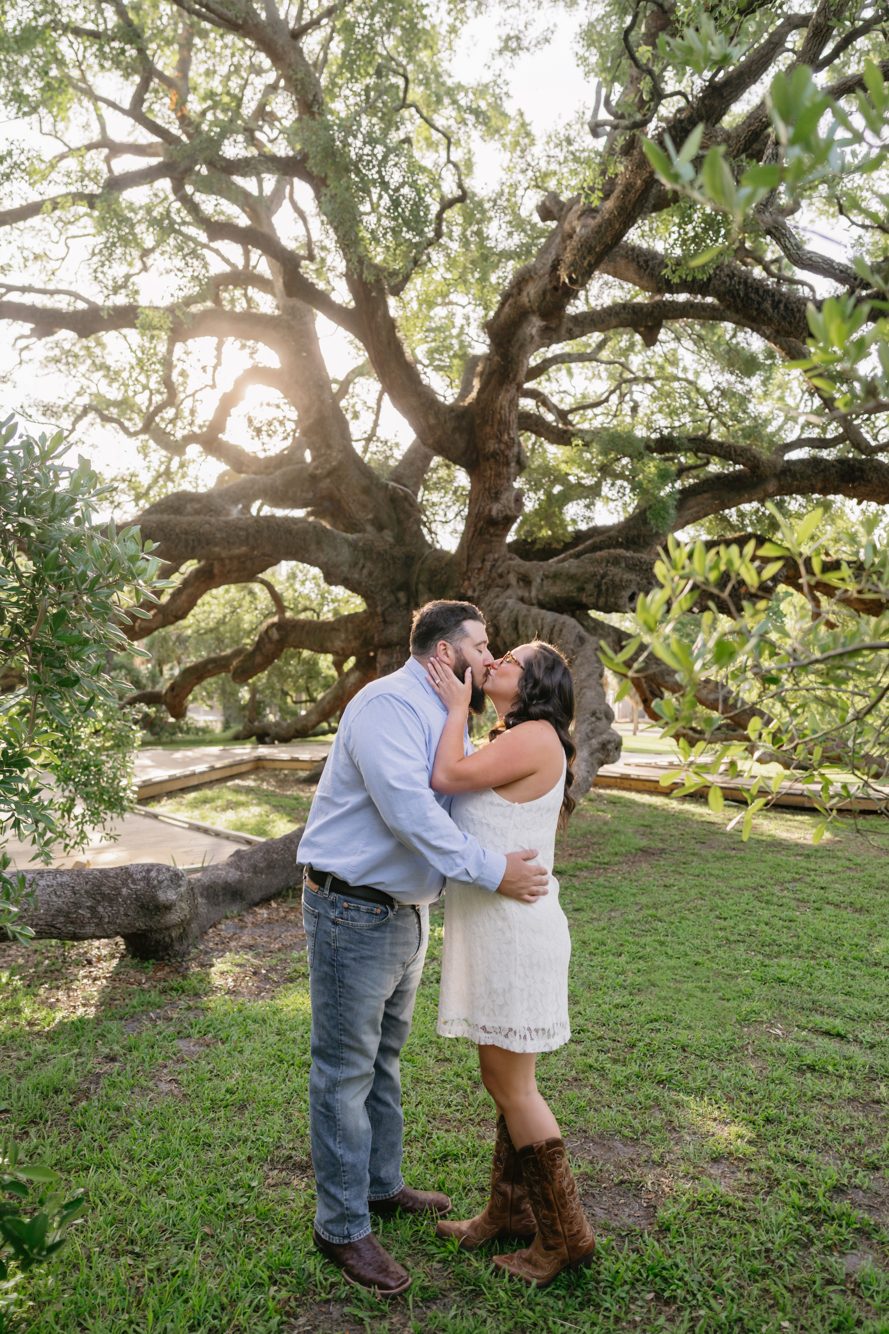 Family with little boy on dad's shoulders in front of the massive Treaty Oak trunk, Jacksonville Florida