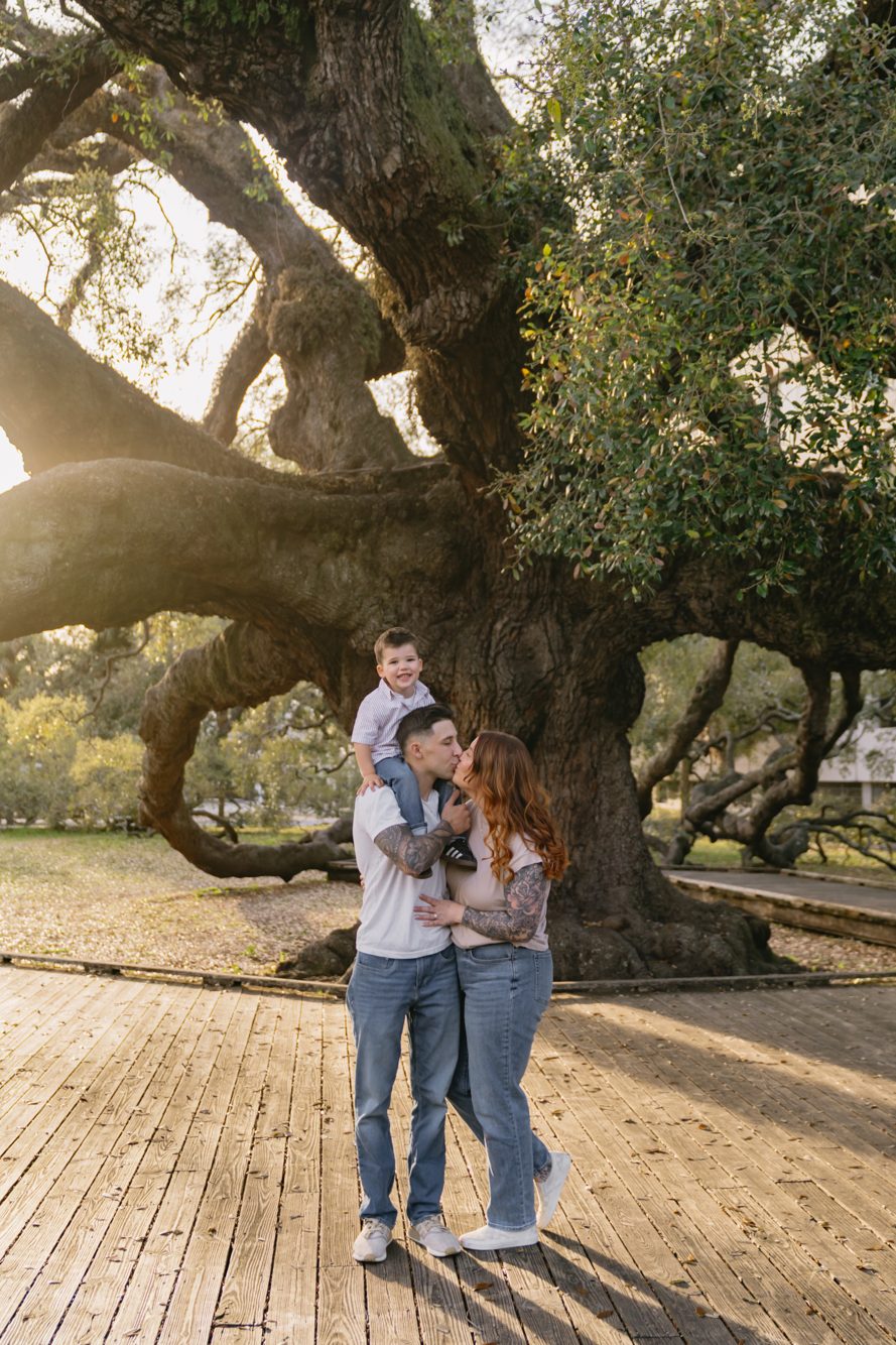 Family with baby walking the boardwalk under the arching branches of the Treaty Oak at Jessie Ball duPont Park, Jacksonville