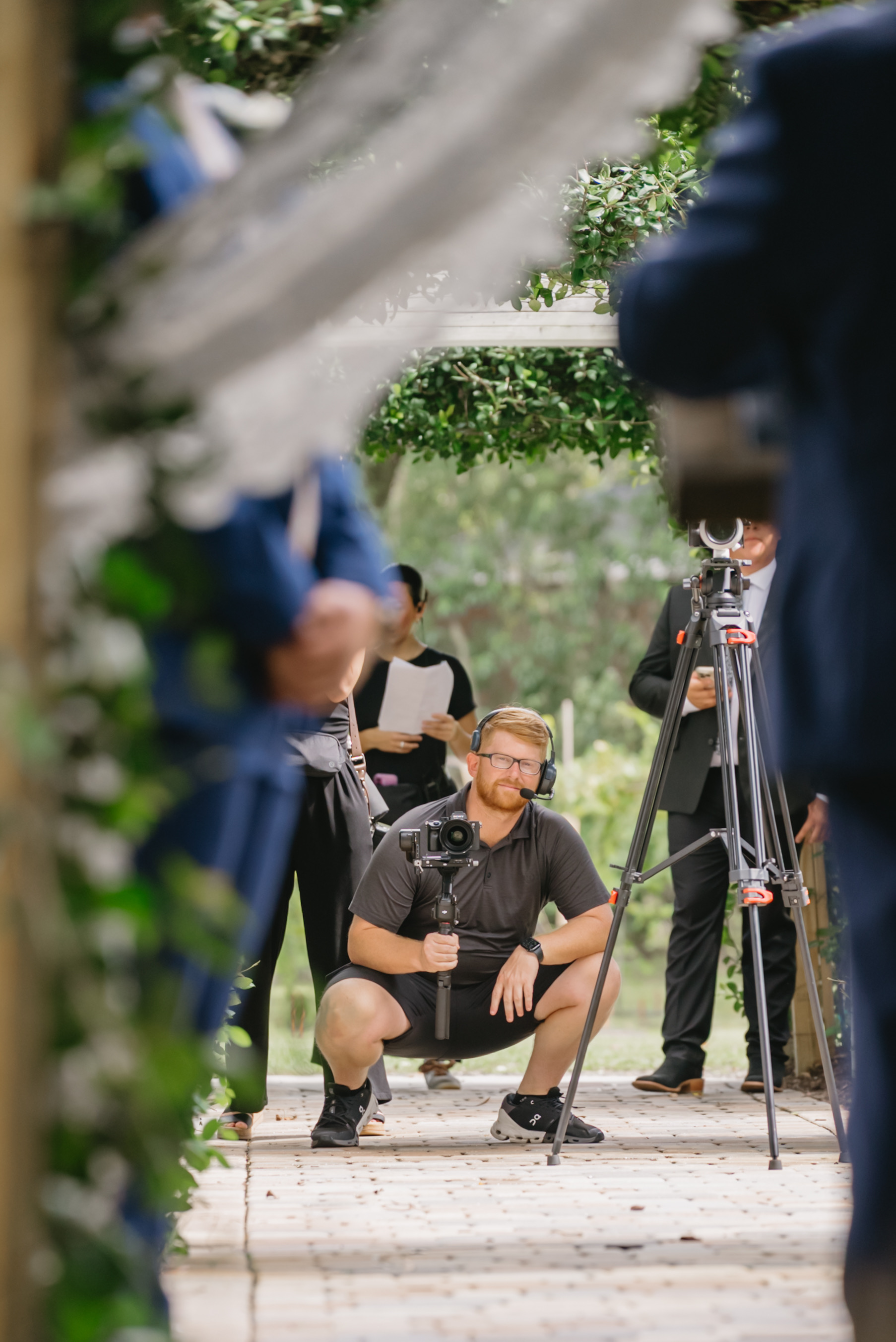 Taylor, wedding videographer at Lee Photo + Video, filming a ceremony