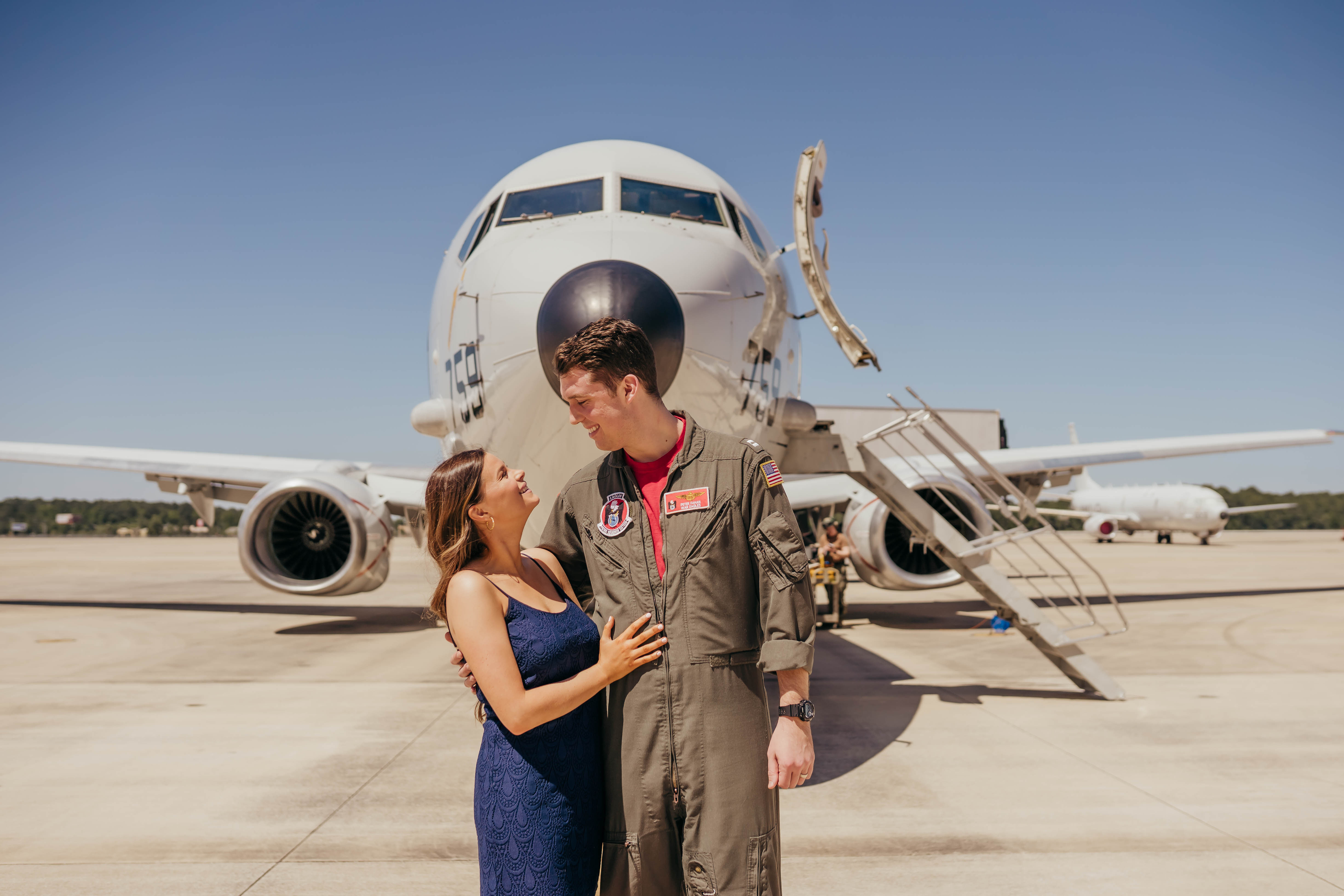 Navy pilot in flight suit embracing spouse on the flight line at homecoming