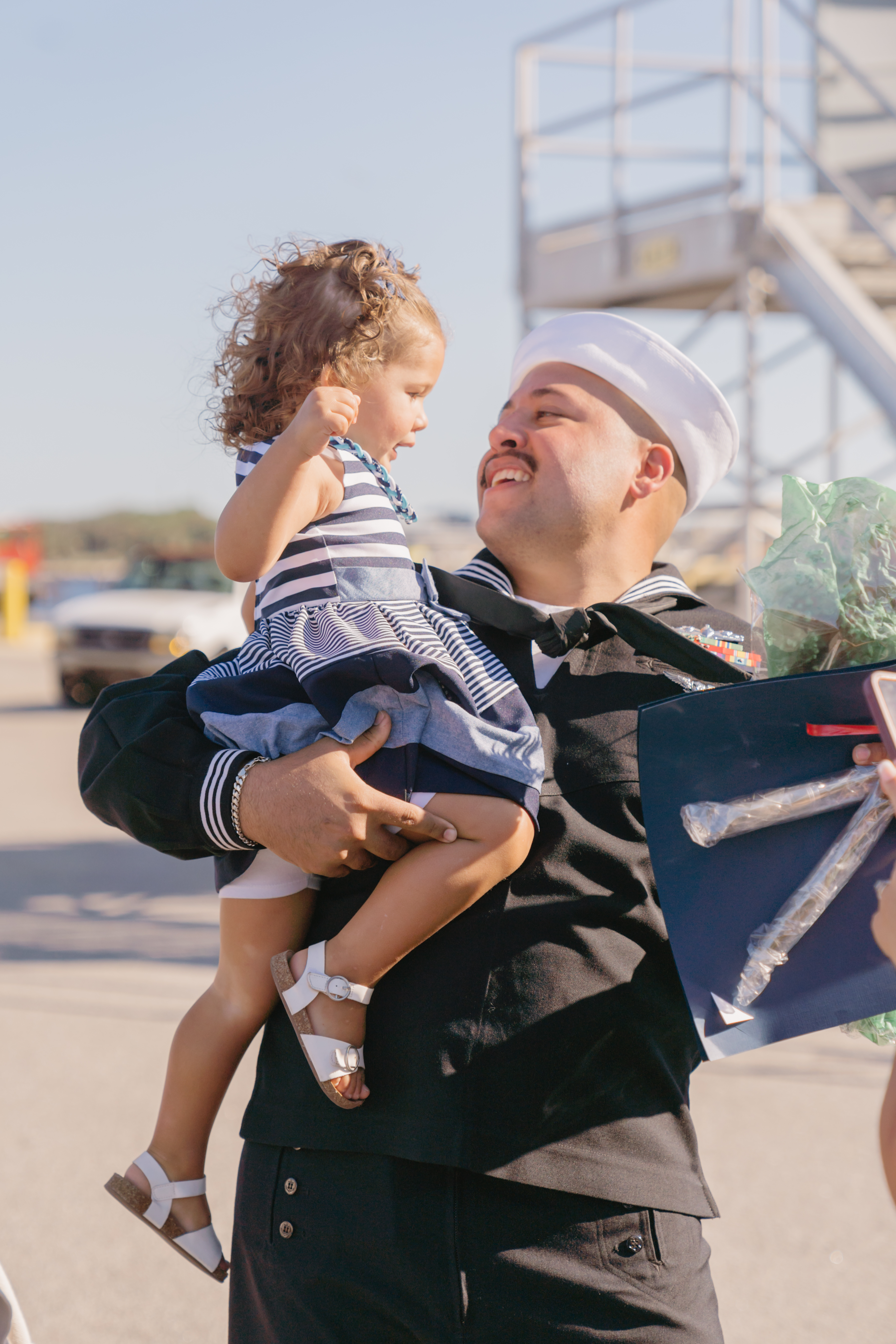 Navy sailor holding his baby daughter at military homecoming in Jacksonville FL