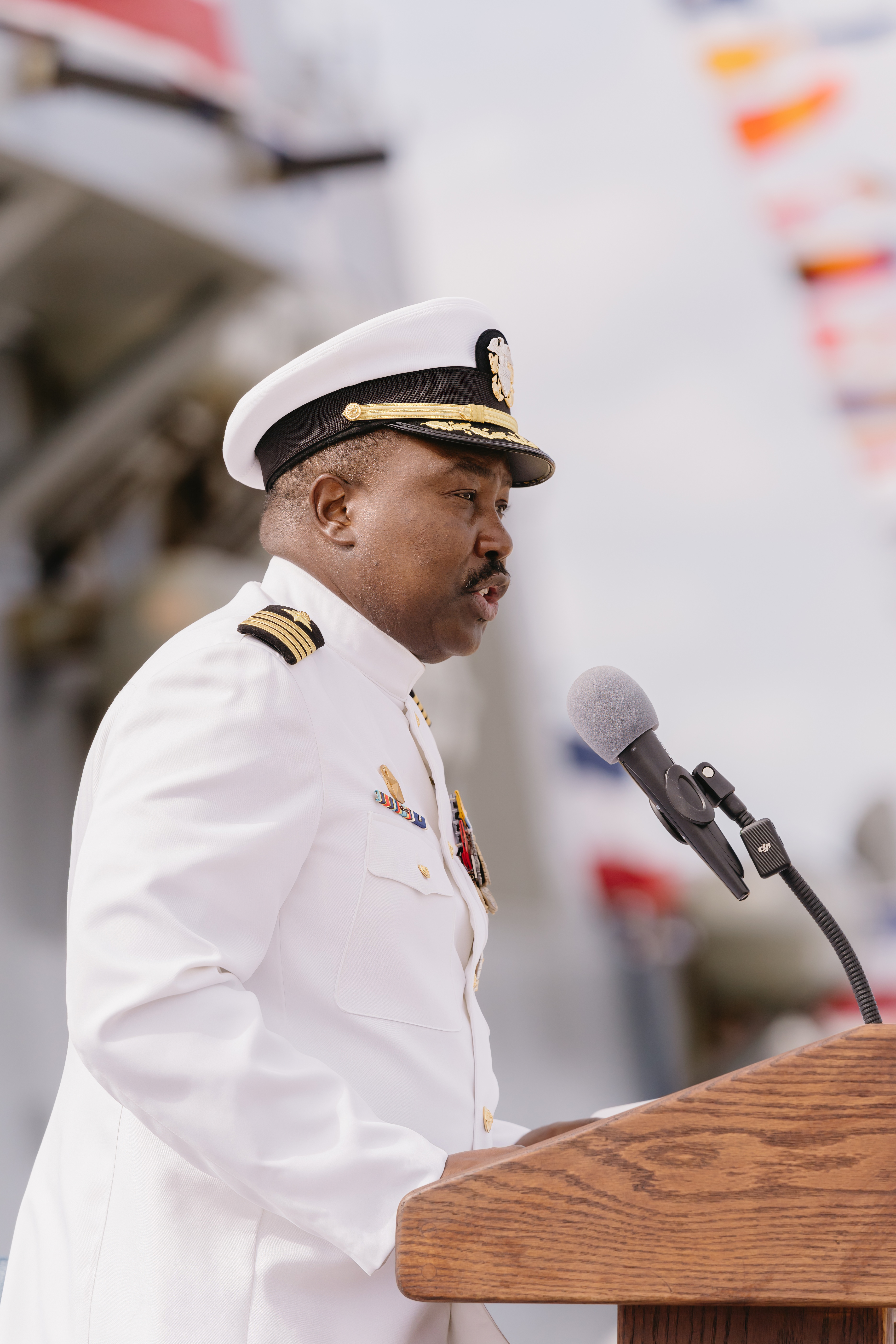 Navy officer in dress whites saluting during retirement ceremony in Florida